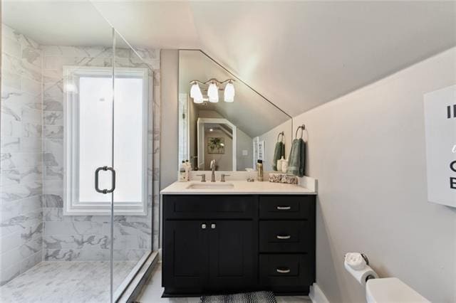 bathroom featuring vaulted ceiling, toilet, a shower stall, and vanity