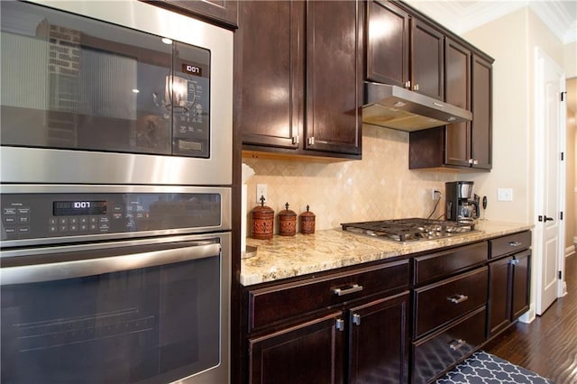 kitchen featuring light stone countertops, stainless steel appliances, ornamental molding, and decorative backsplash