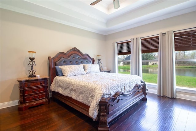 bedroom featuring dark hardwood / wood-style flooring, ceiling fan, and a tray ceiling