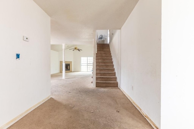 stairway featuring vaulted ceiling, ceiling fan, and carpet flooring