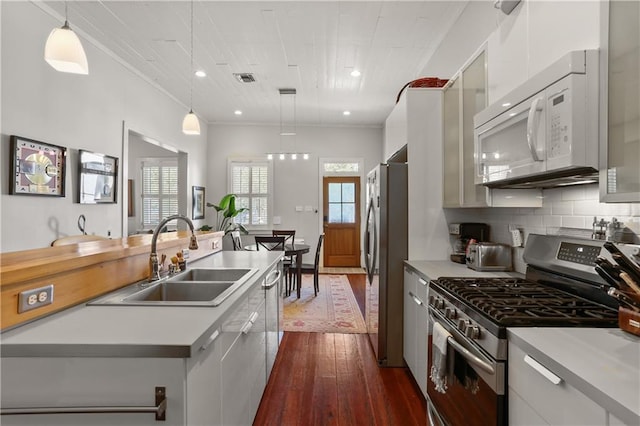 900 Delachaise St, New Orleans, LA 70115 - kitchen with decorative light fixtures, sink, backsplash, appliances with stainless steel finishes, and dark hardwood / wood-style floors