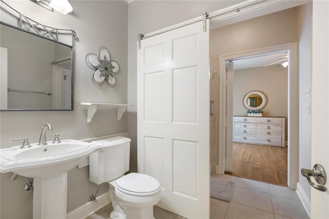 bathroom with sink, toilet, and tile patterned flooring