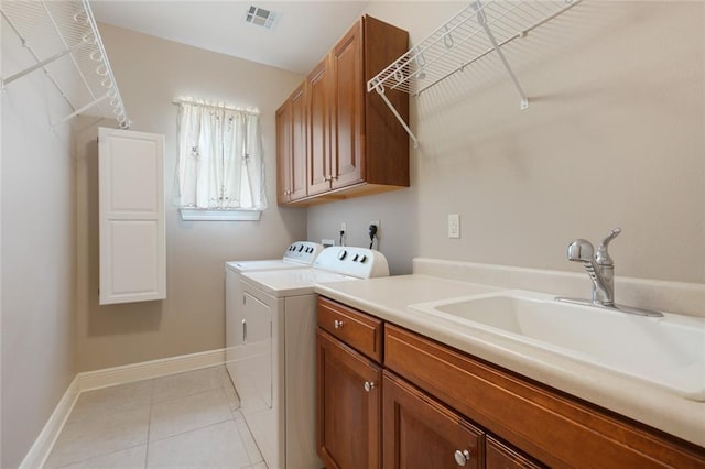 washroom featuring cabinets, light tile patterned floors, washer and clothes dryer, and sink