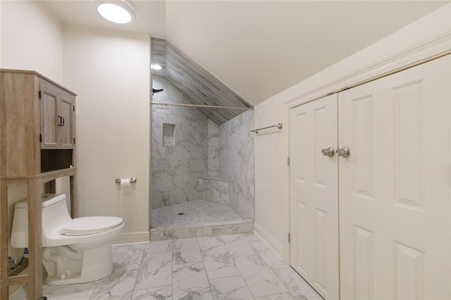 bathroom with toilet, lofted ceiling, and tiled shower