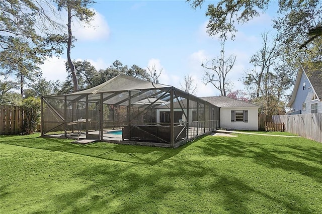 rear view of house with glass enclosure, a lawn, and a fenced in pool