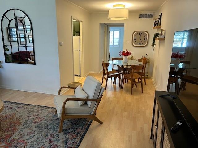 4007 St Charles Ave Unit 319, New Orleans, LA 70115 - dining space featuring light wood-style flooring and crown molding