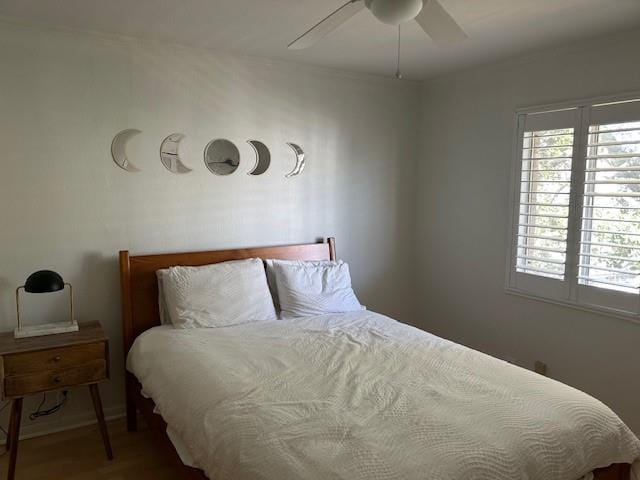 4007 St Charles Ave Unit 319, New Orleans, LA 70115 - bedroom with multiple windows, a ceiling fan, and wood finished floors