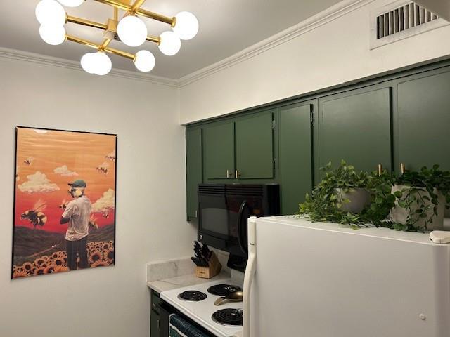 kitchen featuring black microwave, light countertops, green cabinets, and crown molding