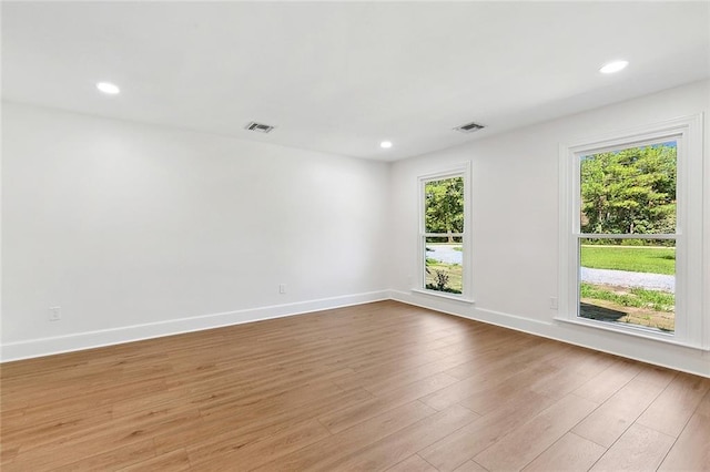 spare room featuring recessed lighting, visible vents, baseboards, and wood finished floors