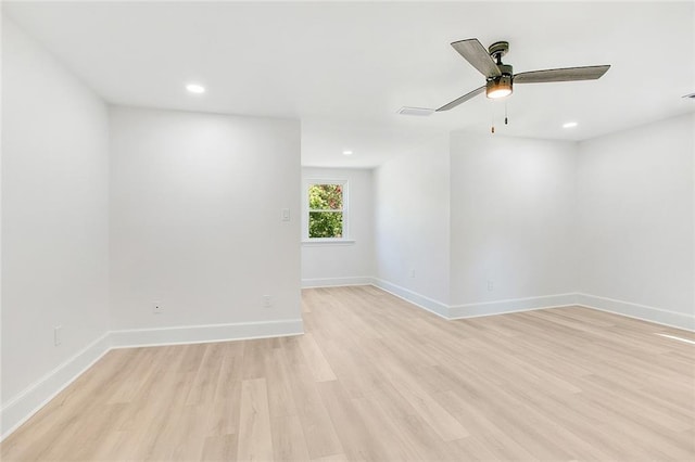 empty room with light wood-type flooring, baseboards, and recessed lighting