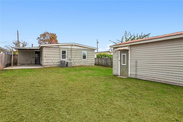 rear view of property featuring central AC, a yard, and a patio area