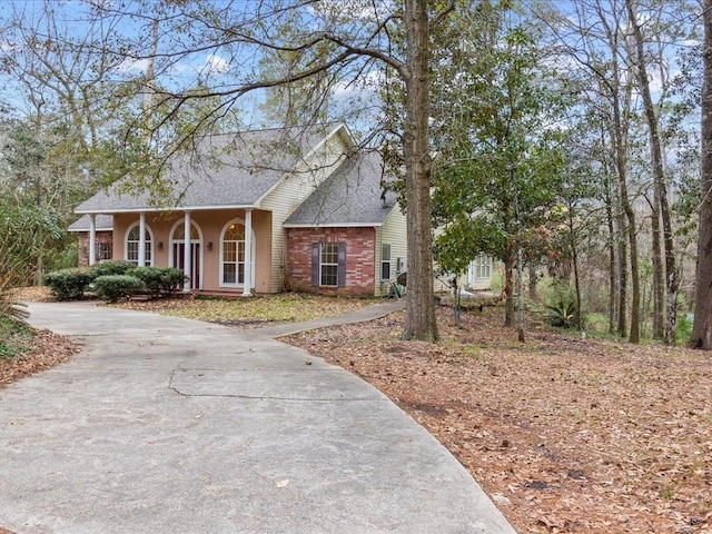 1220 Atalin St, Mandeville, LA 70448 - view of front of house with a porch, roof with shingles, and driveway