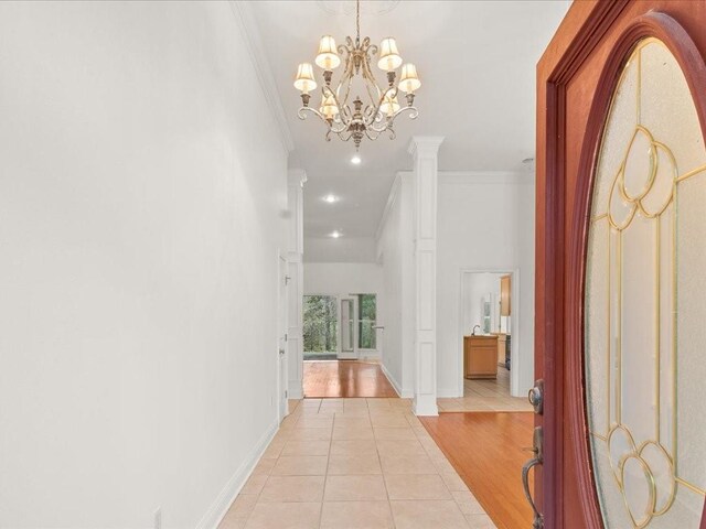 1220 Atalin St, Mandeville, LA 70448 - corridor featuring crown molding, light tile patterned floors, baseboards, decorative columns, and a chandelier