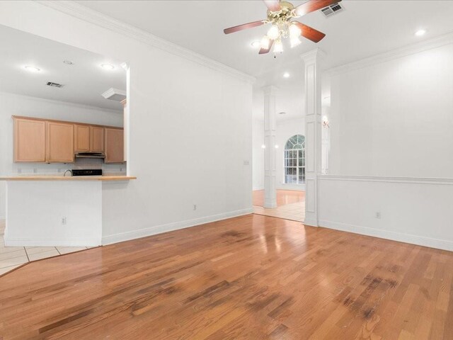 1220 Atalin St, Mandeville, LA 70448 - unfurnished living room with decorative columns, crown molding, ceiling fan, light wood finished floors, and recessed lighting
