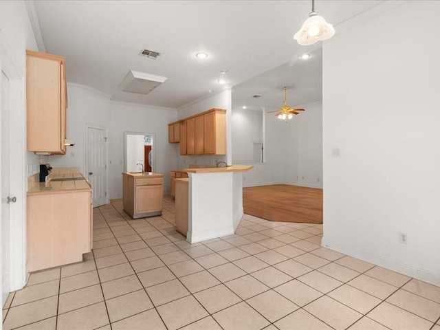 kitchen featuring kitchen peninsula, light brown cabinetry, ceiling fan, and light tile patterned floors