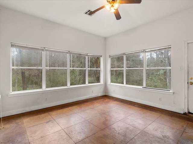 unfurnished sunroom featuring a wealth of natural light and ceiling fan