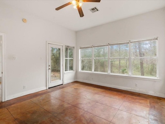 empty room featuring ceiling fan, tile patterned flooring, and a wealth of natural light