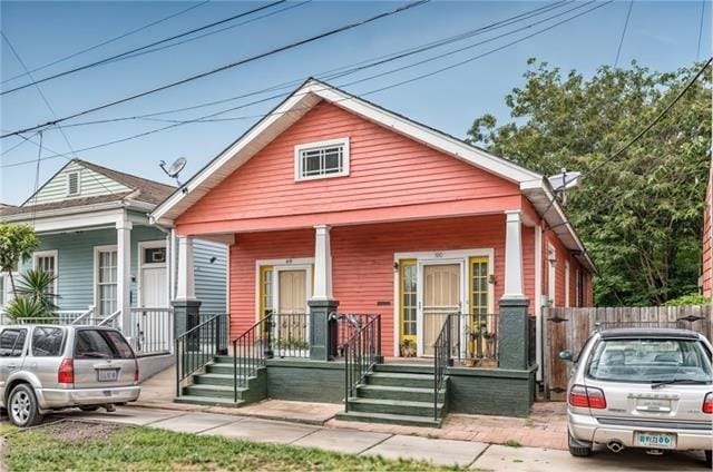 view of front of home with covered porch and fence