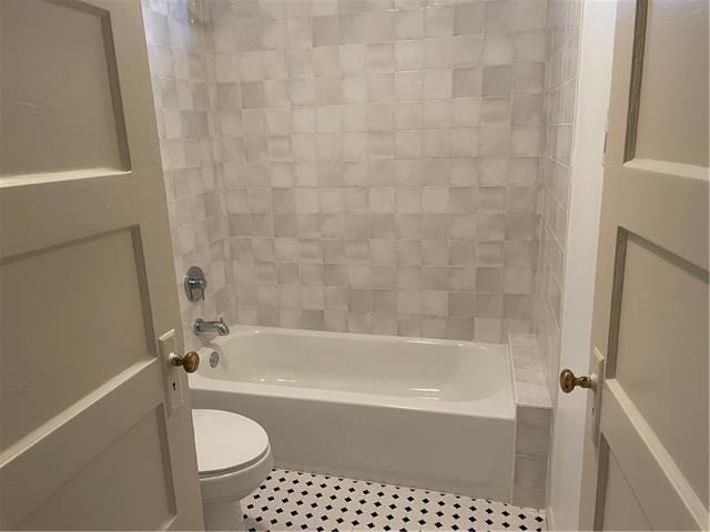 bathroom featuring toilet, tile patterned flooring, and shower / washtub combination