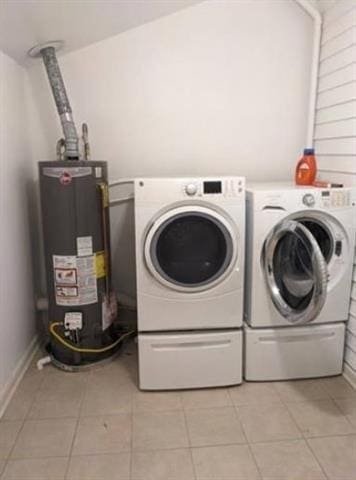 laundry area featuring laundry area, water heater, washing machine and clothes dryer, and light tile patterned floors