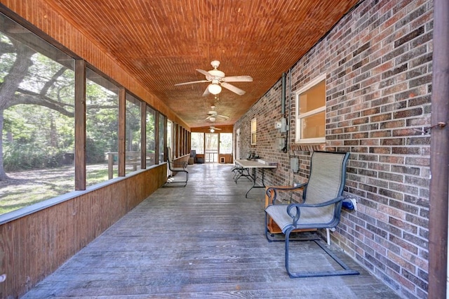 sunroom with ceiling fan and wooden ceiling