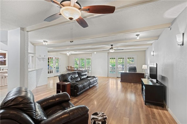 34633 W Dubuisson Rd, Slidell, LA 70460 - living room featuring french doors, light wood finished floors, ceiling fan, beamed ceiling, and a textured ceiling