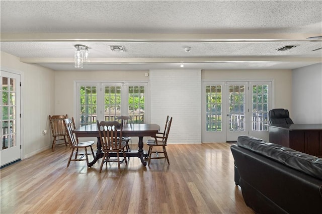 34633 W Dubuisson Rd, Slidell, LA 70460 - dining space with french doors, wood finished floors, baseboards, and a textured ceiling