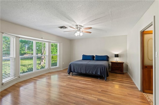 34633 W Dubuisson Rd, Slidell, LA 70460 - bedroom with light wood-style flooring, a textured ceiling, ceiling fan, and baseboards