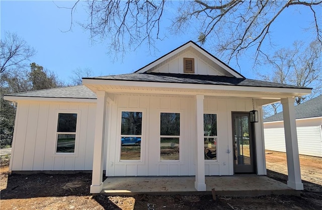 view of side of property featuring board and batten siding and a shingled roof