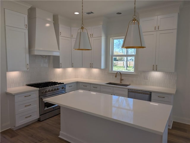 kitchen featuring visible vents, custom exhaust hood, a sink, stainless steel appliances, and light countertops