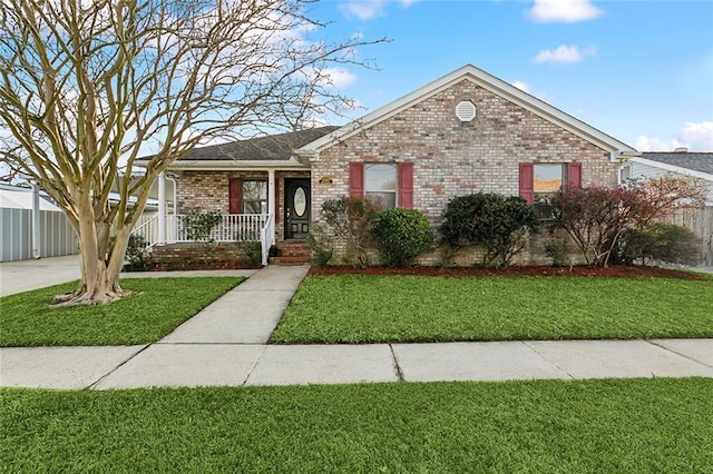 ranch-style house featuring covered porch and a front yard