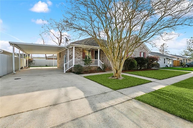 view of front facade featuring covered porch, fence, driveway, a carport, and a front yard