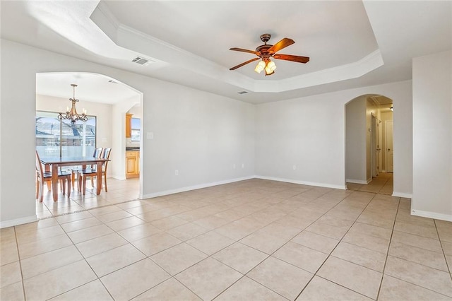 tiled empty room with ceiling fan with notable chandelier, crown molding, and a tray ceiling