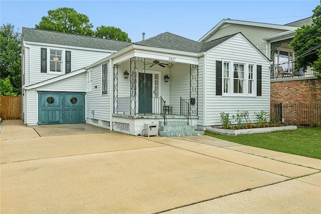 view of front of property featuring a garage, fence, a shingled roof, and driveway