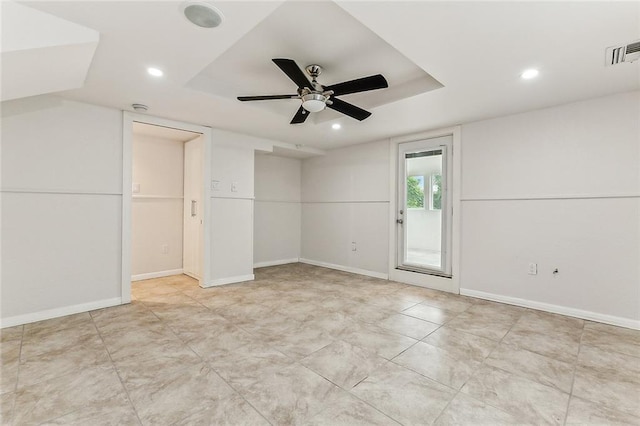 unfurnished room with recessed lighting, a raised ceiling, visible vents, and baseboards