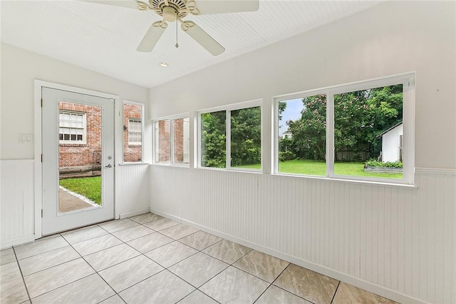 unfurnished sunroom featuring a ceiling fan