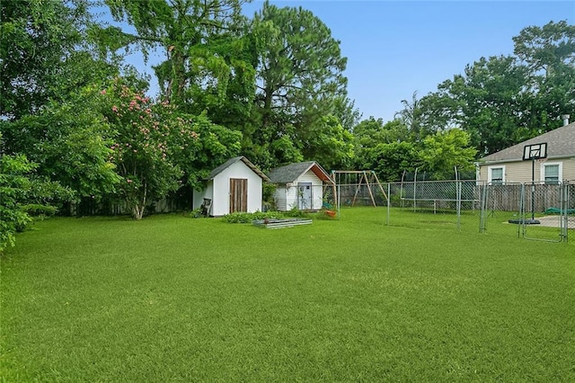 view of yard featuring a fenced backyard, a playground, an outbuilding, and a storage unit