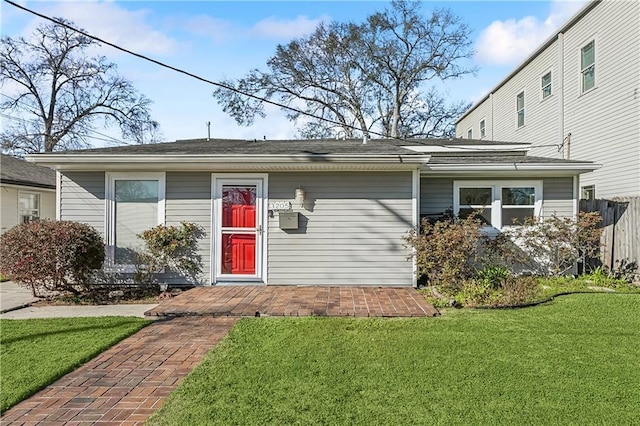 view of front of house featuring fence and a front lawn