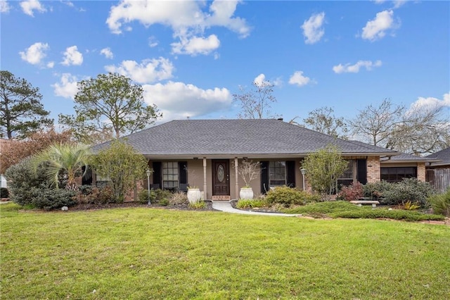 ranch-style house with brick siding, a front yard, and a shingled roof