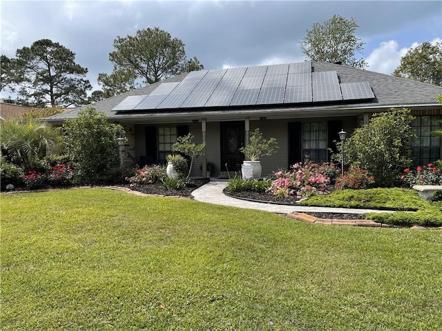 view of front of house with a front lawn and solar panels