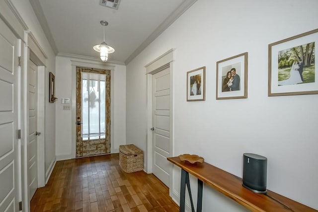 doorway to outside with ornamental molding, dark wood finished floors, and visible vents