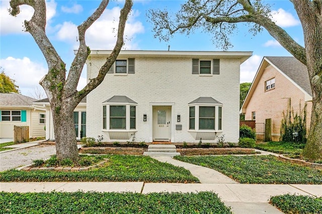 colonial inspired home with brick siding and fence