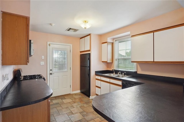 kitchen with black appliances, dark countertops, visible vents, and white cabinets