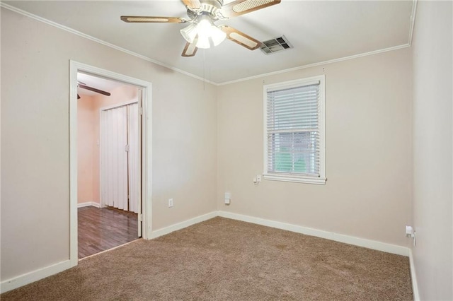 spare room with ornamental molding, carpet flooring, visible vents, and baseboards