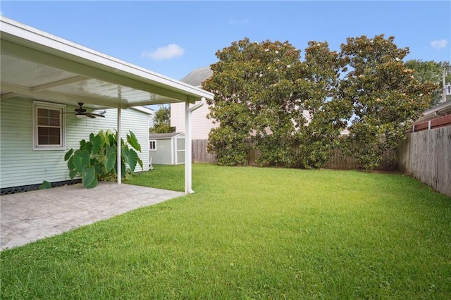 view of yard with an outdoor structure, a fenced backyard, a patio, and a storage shed