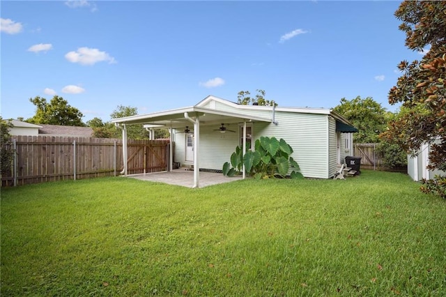 rear view of property with a lawn, a patio area, a fenced backyard, and a ceiling fan