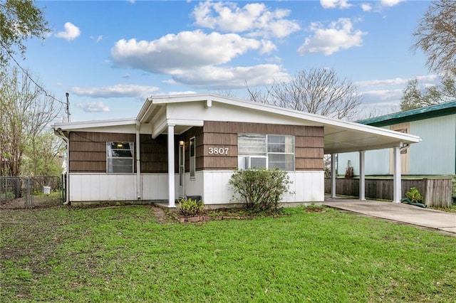 manufactured / mobile home with fence, a front lawn, an attached carport, and concrete driveway