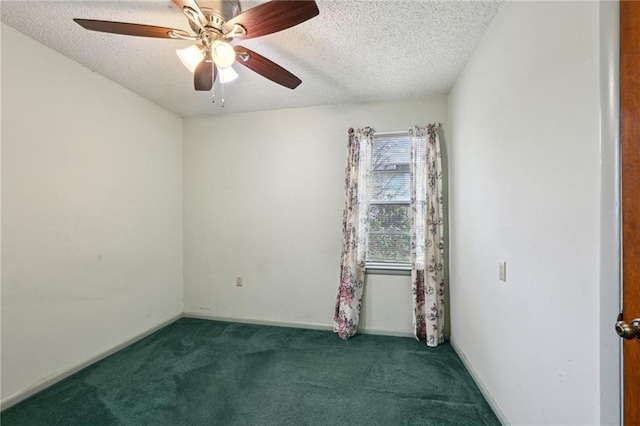 spare room featuring dark colored carpet, ceiling fan, a textured ceiling, and baseboards