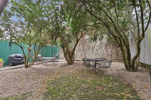 view of yard with outdoor dining space, a patio area, and a fenced backyard