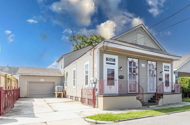 226062 N Roman St, New Orleans, LA 70117 - shotgun-style home featuring an attached garage, a shingled roof, fence, and concrete driveway